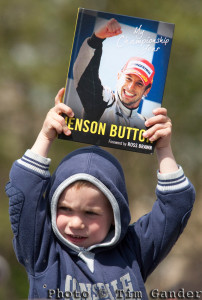 Boy awaits arrival of Jenson Button, holding Jenson Button book.