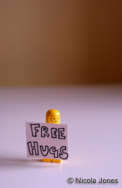 Lego minifigure with Free Hugs sign.