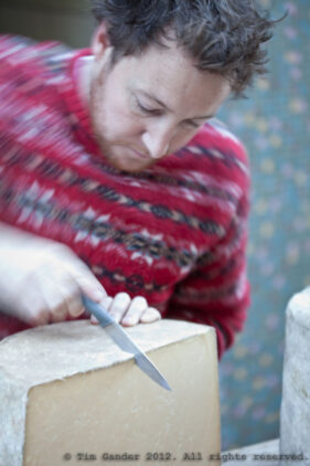 Cheese-maker cuts a round of cheese at Frome Super Market