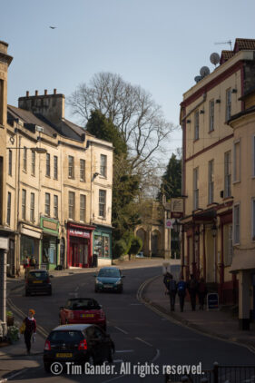 A view of Frome's Bath Street taken from Cork Street showing the shop buildings, road, traffic and pedestrians