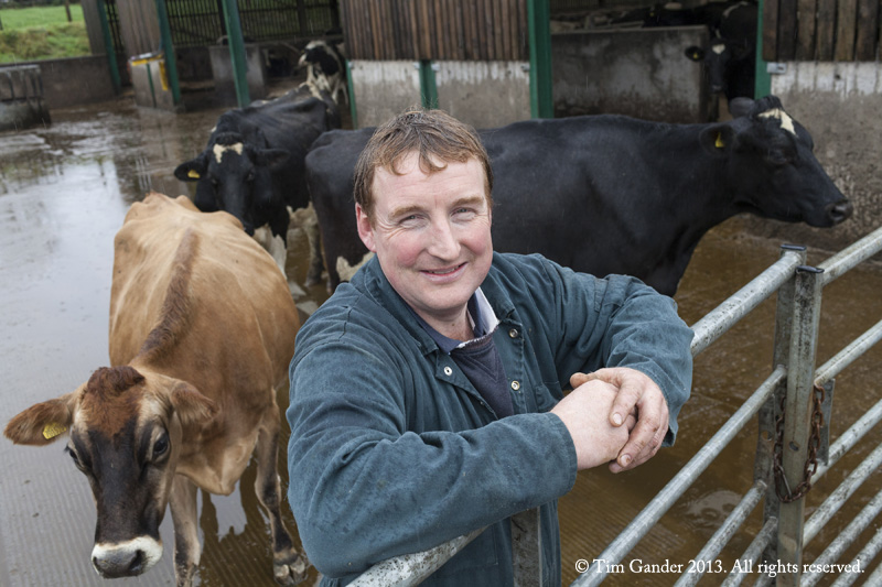 Dairy farmer Philip Cotterrell smiles at the farm gate as he's surrounded by cows