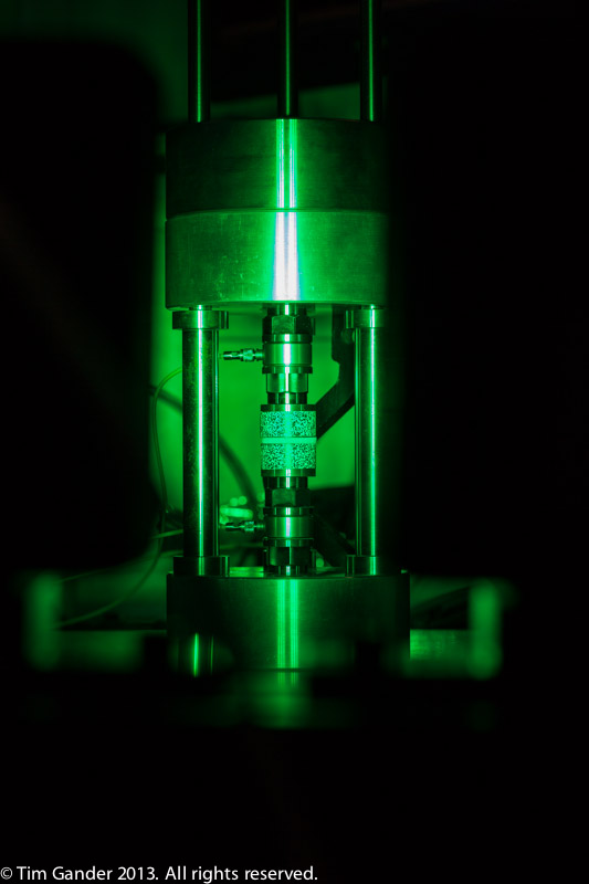 A scientific instrument glows green in a dark surrounding