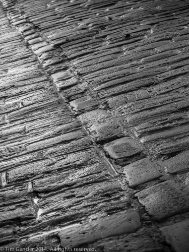 Angled detail view in black and white of cobbled street, Frome