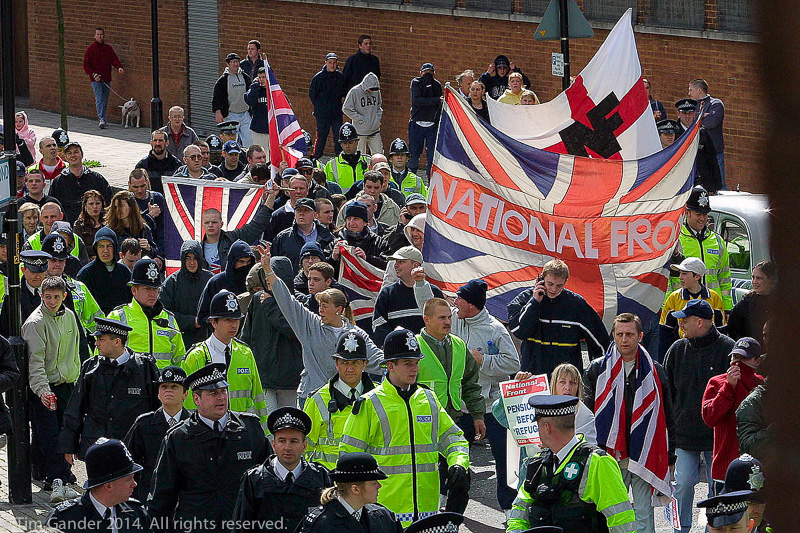 Supporters of the National Front are escorted through the streets of Bermondsey by police officers.