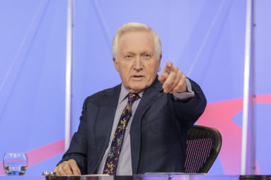 David Dimbleby chairs BBC Question Time, filmed at University of Bath. He points to the audience to take the next question.