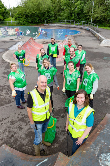 A team of litter pickers standing in a skate park in Peg Hill play area, Bristol.