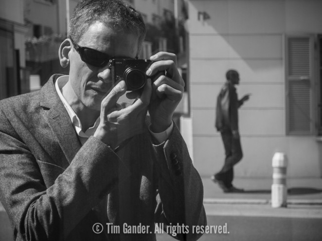 Self-portrait of Tim Gander reflected in a shop window near Paris