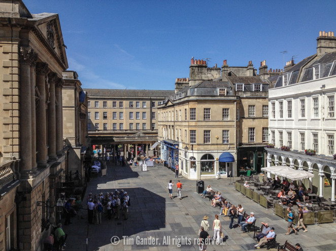 A high-level view of Bath Abbey Churchyard, taken from above the abbey door on a sunny day.