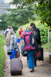 School pupils in casual clothes arrive at University of Bath campus with suitcases