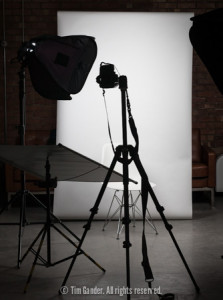 A portrait photography setup with lights, backdrop and camera on a tripod.