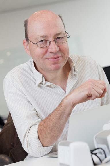 Ben Morris of Connected Digital Economy Catapult at his desk in London, smiling to camera while seated at his desk.