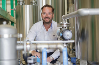 James Hygate of green fuel company Greenfuels crouches within the pipes and tanks of a green fuel distillery.