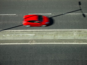 Aerial view of a red car blurred along a dual carriageway in Derby, UK