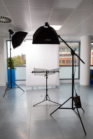 A portable photographic studio lighting setup in a client office space.