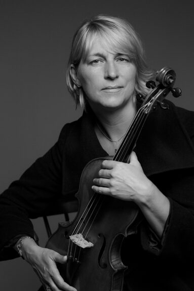 Black and white portrait of musician Rachel Byrt holding her viola.