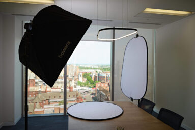 A portable photographic studio lighting setup in a client office space.