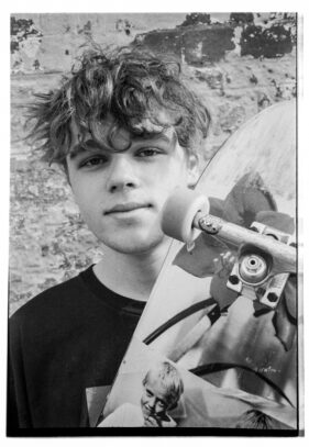 Finlay John poses with his skateboard outside the Cheese and Grain in Frome, Somerset, UK.