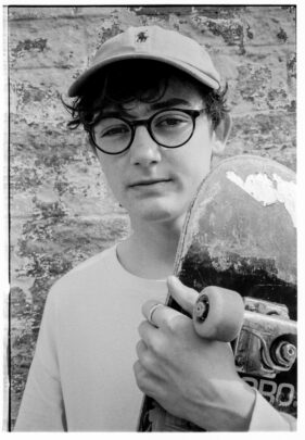 Christy Meape poses with his skateboard outside the Cheese and Grain in Frome, Somerset, UK.