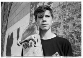 Toby Baudains-Bourne poses with his skateboard outside the Cheese and Grain in Frome, Somerset, UK.