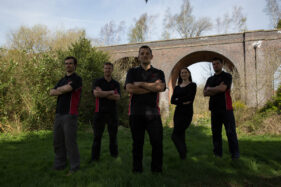 The Bristol Pest Controller team outside in a park in Bristol with a railway viaduct behind.