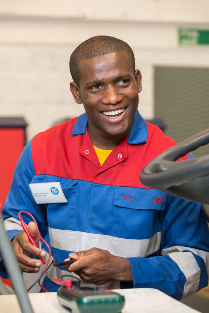 A young, black, male engineer works on a bus's electrical circuit for the IRTE Skills Challenge 2017.