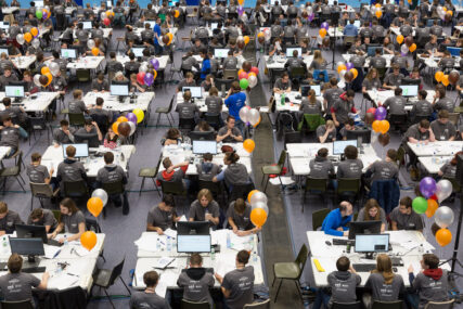 A high vantage point view of students at tables working at computers during the 2017 NWERC regional finals.