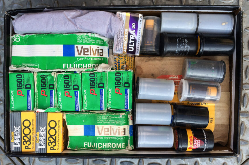 An above view of a shoebox of various expired Kodak, Ilford, Fuji and Agfa photographic film.