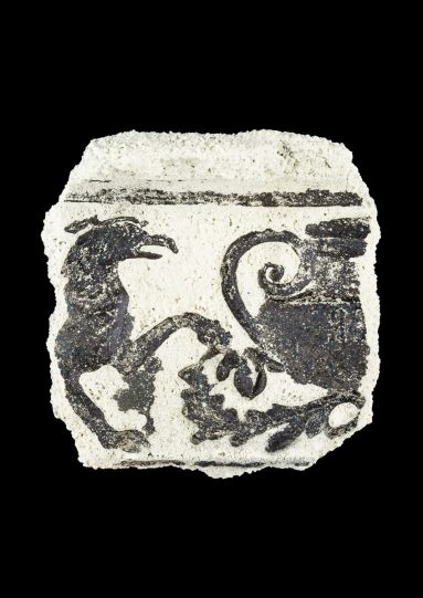 Impression of mythical creature and pot design in ceramic fragment.