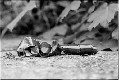 Black and white ground-level view of an unfurled canister of 35mm film.