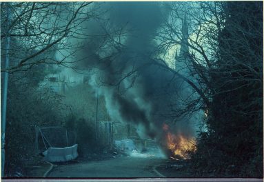 Colour photo view looking into the Saxonvale site as smoke and flames pour from Alby's caravan.