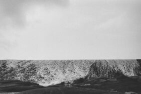 A curtain of sea water breaks over a sea wall.