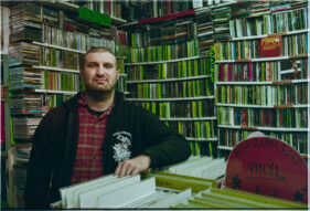 Portrait of manager of Raves from the Grave Tom Coates surrounded by records and CDs.