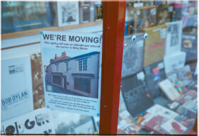 A sign in the shop window announces the date of the move and the new address.