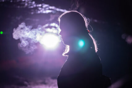 In Wookey Hole cave, a silhouetted singer's breath looks like smoke in the cold air of the cave.