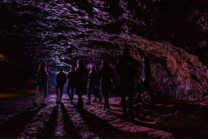 A choir is silhouetted in Wookey Hole cave.