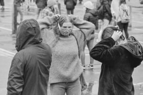 People get their masks on prior to the start of the rally.