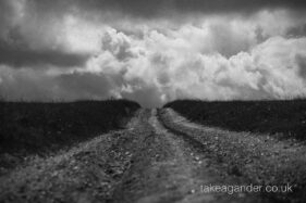 Moody black and white landscape of a chalk track leading to the near horizon on Salisbury Plain