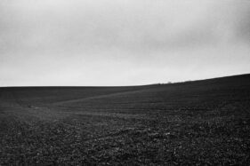 Black and white landscape of a ploughed field.