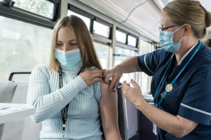 A college student receives her Covid vaccination on board a bus.