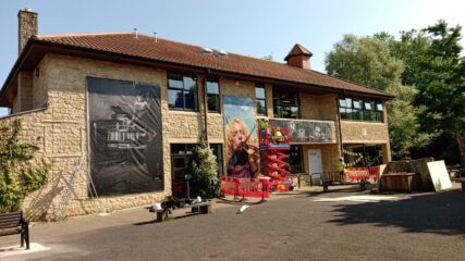 Wide view of the Frome Library showing some of the vinyl prints already installed and Alex with Alex and me working on the scissor lift.