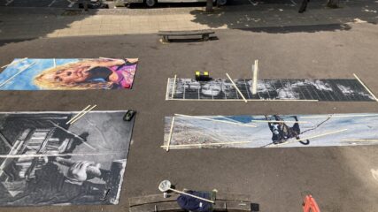 High view looking down on the vinyl prints laid out on the ground.