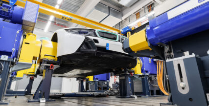 Photo is a low-angle view of a BMW on a test rig.