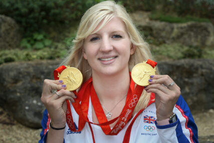 Double gold-medal swimmer Rebecca Adlington holds her two gold medals while looking to camera.